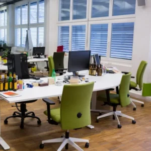 Creative office interior with green chairs and collaborative workspace