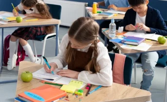 classroom desk with school supplies and books